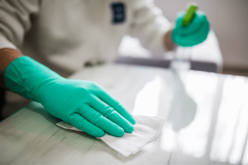 a worker cleaning and spraying disinfectant