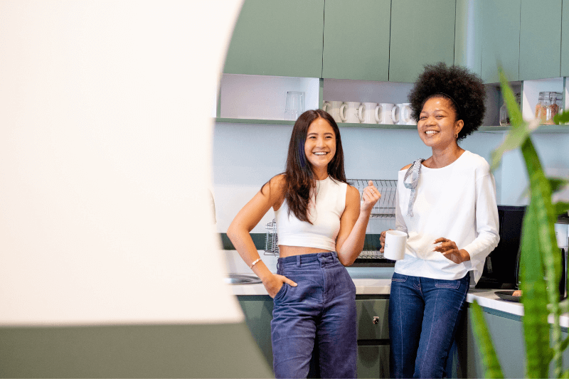 two women hanging out in the office pantry