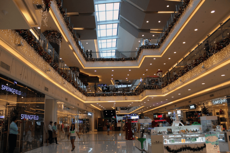 a large building with with christmas decors and people buying gifts for Christmas in the Philippines