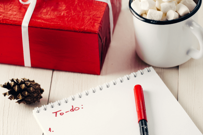 a notebook with a pen and a cup of marshmallows next to it