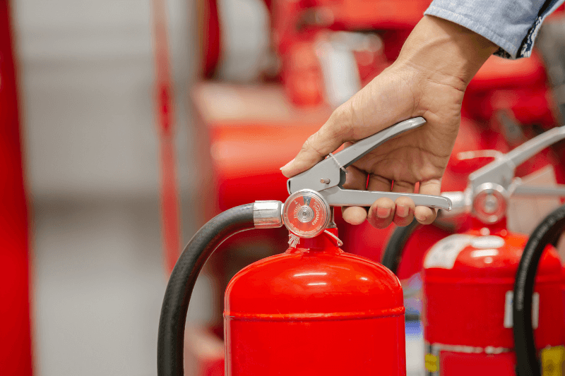 a hand holding a fire extinguisher