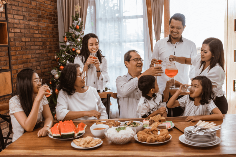 a group of people drinking and eating food together during Christmas 