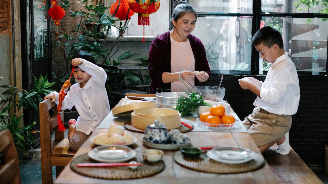 A woman and two children enjoy a meal together at a table, celebrating the spirit of Chinese New Year with festive food.