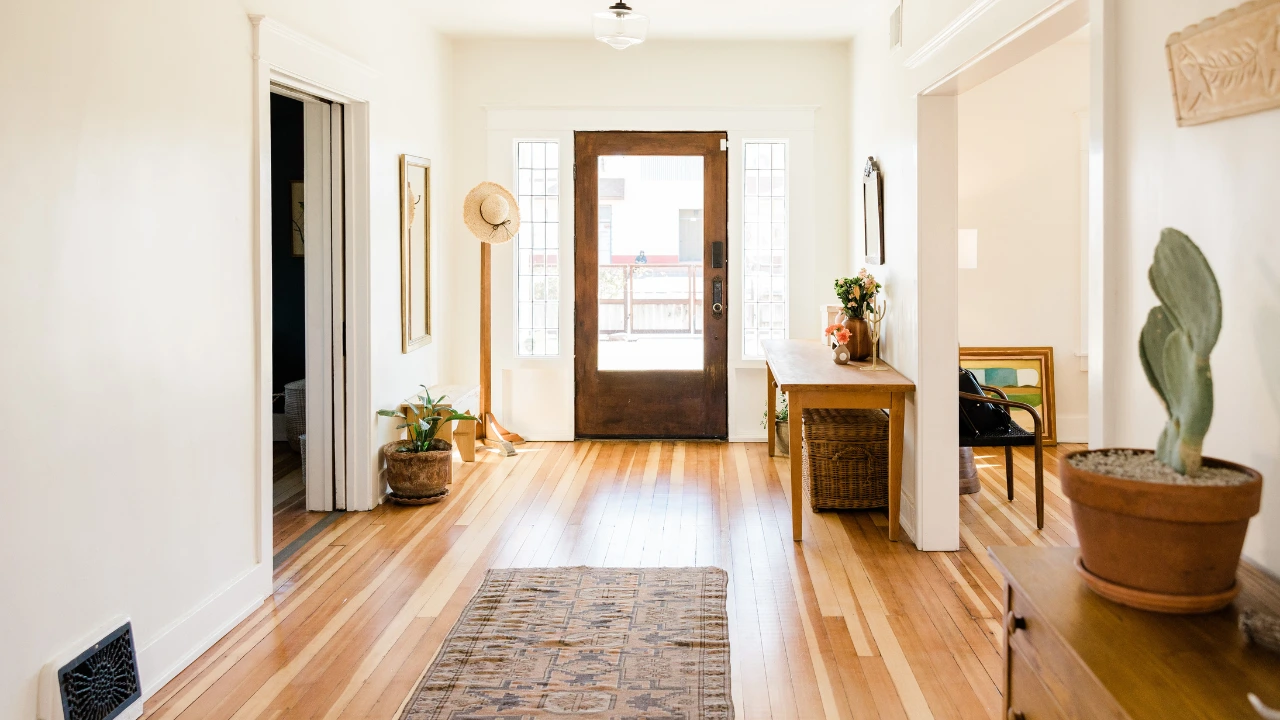 A tidy hallway showcasing a wooden floor and a door, illustrating pest control strategies for homeowners seeking cleanliness.