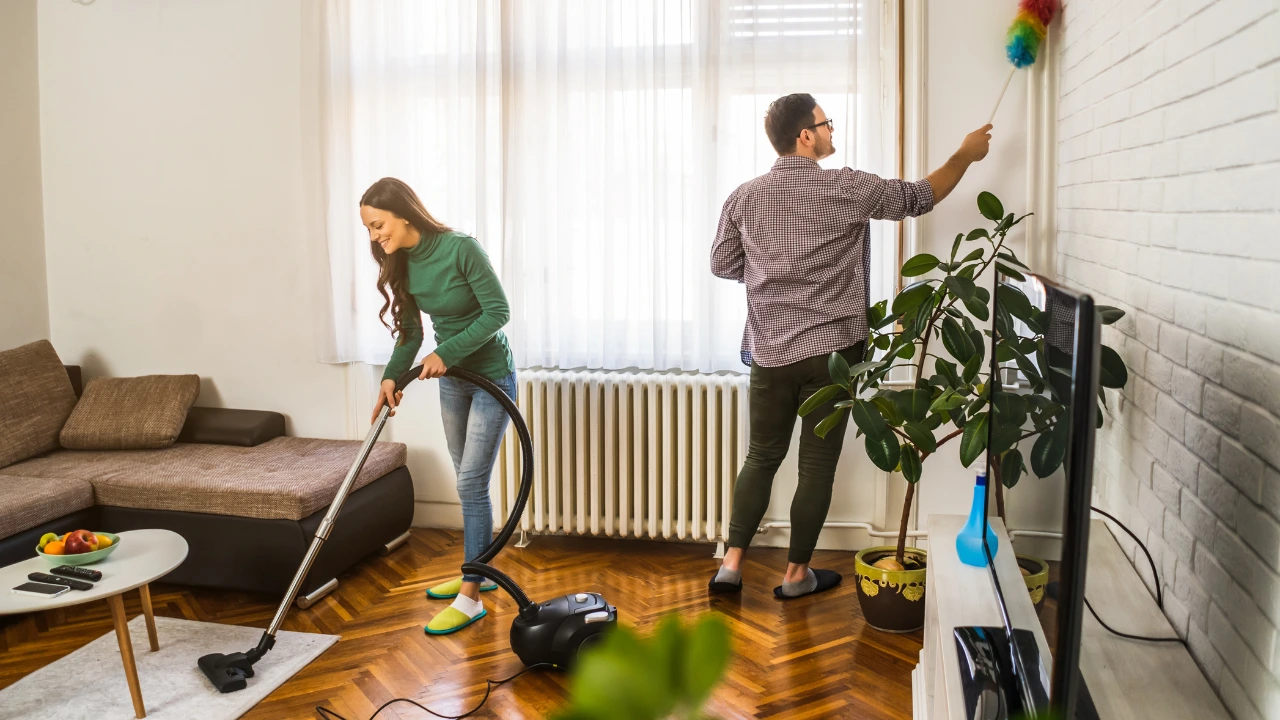 A couple diligently cleaning a room with a vacuum, emphasizing a rat-free environment and a love for their home.