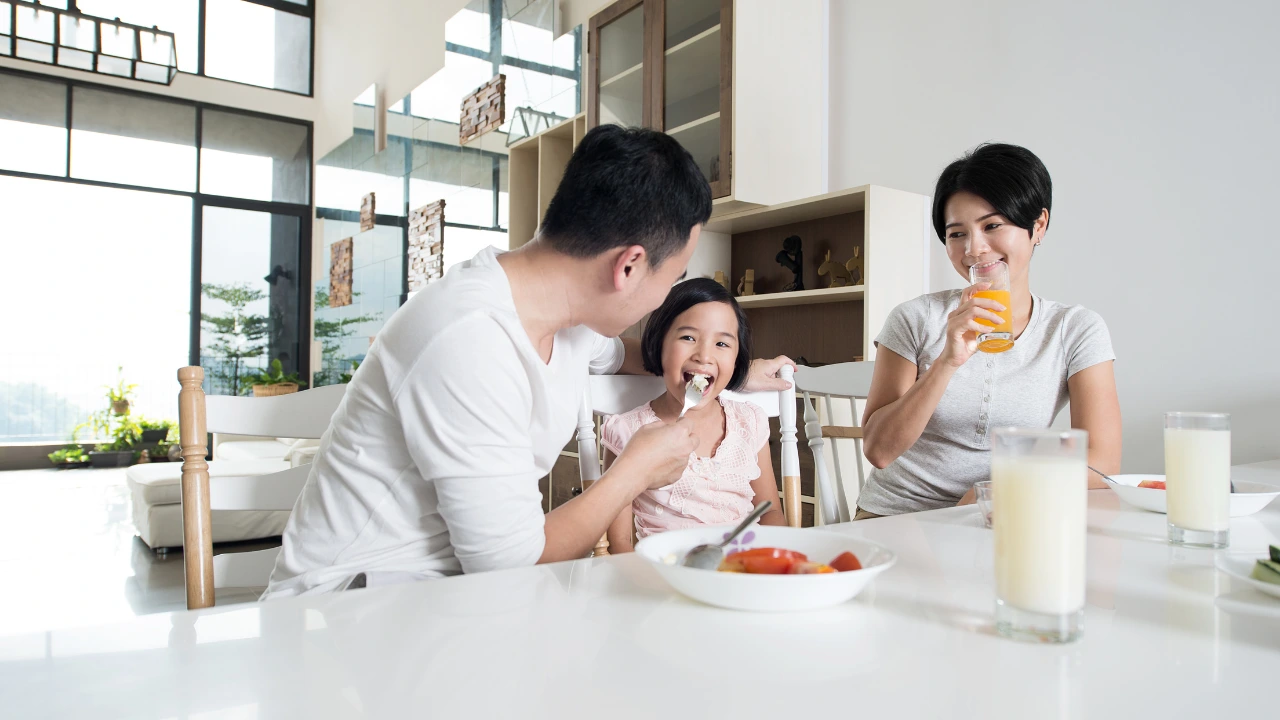 A family enjoys breakfast together in a modern home, symbolizing love and health in a pest-free environment.