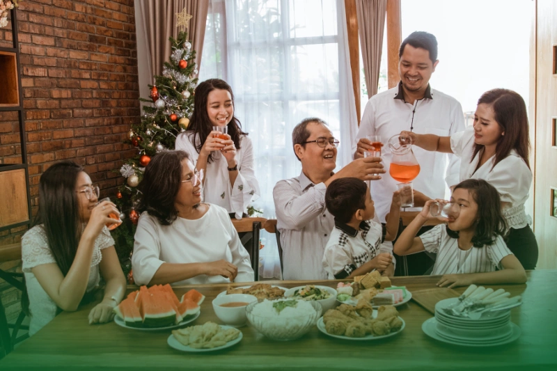a group of people drinking and eating food together during Christmas