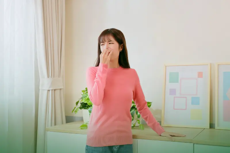 Unpleasant Odors a woman in pink covering her nose due to bad smell