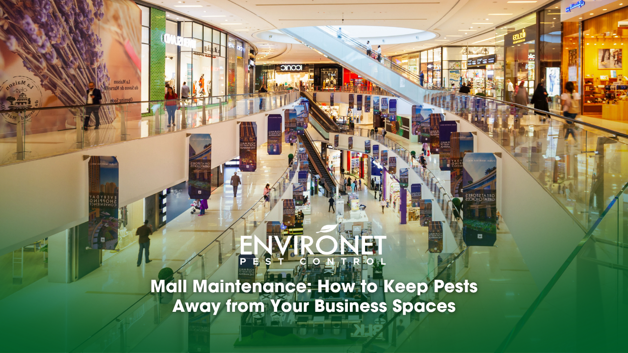 Crowded mall interior with numerous shoppers and a maintenance team working on upkeep in the background.